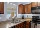 Functional kitchen featuring dark wood cabinets, stainless sink and stove at 13923 Pathfinder Dr, Tampa, FL 33625