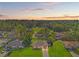 An aerial dusk view of a home in a residential area featuring lush green trees at 13935 Coronado Dr, Spring Hill, FL 34609