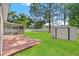 Spacious backyard features a screened patio, storage shed, and lush lawn at 13935 Coronado Dr, Spring Hill, FL 34609