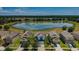 Aerial view of a blue home featuring a pond, lush landscaping, and a beautiful neighborhood at 14008 Lugano Ct, Hudson, FL 34669