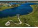 Breathtaking aerial view of the lake with a pier and a fire pit with Adirondack chairs at 14008 Lugano Ct, Hudson, FL 34669