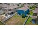 Aerial view of a fenced yard featuring a blue house, a fire pit, and well-maintained landscaping at 14008 Lugano Ct, Hudson, FL 34669