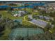 Aerial shot of community amenities: pool, tennis courts, basketball court, playground, clubhouse, and a parking area at 14008 Lugano Ct, Hudson, FL 34669