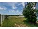 The spacious backyard offers a fire pit, vibrant green grass, privacy fencing, and a serene water view at 14008 Lugano Ct, Hudson, FL 34669