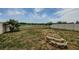 Backyard showcasing a white fence, verdant grass, stone fire pit, and picturesque water view at 14008 Lugano Ct, Hudson, FL 34669