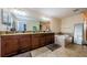 The bathroom features dual sinks, granite countertops, dark wood cabinets, and a tiled soaking tub at 14008 Lugano Ct, Hudson, FL 34669