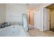 Bright bathroom featuring a soaking tub, glass-enclosed shower, and ample natural light at 14008 Lugano Ct, Hudson, FL 34669
