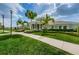 Inviting clubhouse exterior featuring manicured landscaping and a well-lit walkway at 14008 Lugano Ct, Hudson, FL 34669