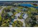 Aerial view showing a pool, lake, tennis courts and the layout of the community at 14008 Lugano Ct, Hudson, FL 34669