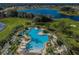 Aerial view of the resort-style pool with palm trees and ample lounging space at 14008 Lugano Ct, Hudson, FL 34669