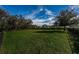 Open green space within the fenced dog park provides a secure area for dogs to play and exercise with lush landscaping around it at 14008 Lugano Ct, Hudson, FL 34669