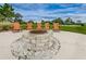 Close-up view of the fire pit surrounded by Adirondack chairs in a green community park at 14008 Lugano Ct, Hudson, FL 34669