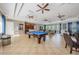 Spacious game room with pool table, comfortable couches, TV, tile floor, kitchen, and ceiling fans at 14008 Lugano Ct, Hudson, FL 34669