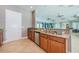 Eat-in kitchen featuring stainless steel dishwasher, sink, granite counters, wood cabinets, and tile flooring at 14008 Lugano Ct, Hudson, FL 34669