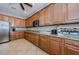 Kitchen with stainless steel appliances, granite countertops, wood cabinets, tile floors, and ceiling fan at 14008 Lugano Ct, Hudson, FL 34669