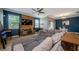 Comfortable living room featuring a rustic wood accent wall, tile floors, and a ceiling fan at 14008 Lugano Ct, Hudson, FL 34669