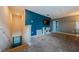 Spacious loft area featuring a blue accent wall, neutral carpeting, a built-in shelf, and a staircase at 14008 Lugano Ct, Hudson, FL 34669