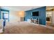 An open loft space with a blue accent wall, comfortable carpeting, and easy access to other rooms at 14008 Lugano Ct, Hudson, FL 34669