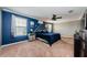 A primary bedroom with a statement wall, ceiling fan, and plenty of natural light streaming through large windows at 14008 Lugano Ct, Hudson, FL 34669