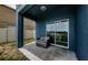 Relaxing covered patio featuring a lounge chair and glass sliding doors to the interior at 14008 Lugano Ct, Hudson, FL 34669