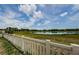 White fence overlooking a tranquil pond on the property, creating a serene outdoor atmosphere at 14008 Lugano Ct, Hudson, FL 34669