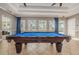 Close up shot of community pool table with blue felt and dark wood frame, near exit and windows at 14008 Lugano Ct, Hudson, FL 34669