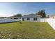 Large backyard with a well maintained lawn, white fence, and a fire pit; great for outdoor enjoyment at 15159 Durango Cir, Brooksville, FL 34604