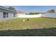 Wide backyard with a white fence, green grass, and a spot for a fire pit at 15159 Durango Cir, Brooksville, FL 34604
