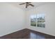 Bright bedroom with a ceiling fan, laminate flooring, and large window overlooking the neighborhood at 15159 Durango Cir, Brooksville, FL 34604