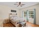 Inviting bedroom featuring a decorative headboard, ceiling fan, and bright natural lighting at 15613 Charmwood Dr, Hudson, FL 34667