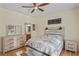 Cozy bedroom with ceiling fan, complemented by natural light and a charming decor at 15613 Charmwood Dr, Hudson, FL 34667
