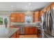 Modern kitchen with stainless steel appliances, wood cabinets, and a center island for meal preparation at 15613 Charmwood Dr, Hudson, FL 34667