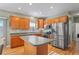 Well-appointed kitchen with stainless steel appliances, wood cabinets, and a convenient center island at 15613 Charmwood Dr, Hudson, FL 34667