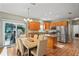 Open kitchen featuring stainless steel appliances, wood cabinets, and a breakfast bar that overlooks the dining area at 15613 Charmwood Dr, Hudson, FL 34667