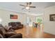 Open-concept living space with hardwood floors, ceiling fan, and living/dining room combo at 15613 Charmwood Dr, Hudson, FL 34667