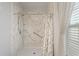 Modern bathroom shower with marble-style tiling, sleek fixtures, and abundant natural light at 15613 Charmwood Dr, Hudson, FL 34667