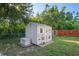 Charming backyard storage shed with custom paint and adjacent storage chest at 15613 Charmwood Dr, Hudson, FL 34667