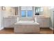 Relaxing bathroom features a large soaking tub, dual vanities, and a window for natural light at 16697 Courtyard Loop, Land O Lakes, FL 34638