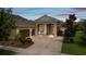 Inviting home exterior showcasing a spacious driveway, two-car garage, and covered entryway at 16697 Courtyard Loop, Land O Lakes, FL 34638