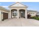 Inviting home exterior featuring an elegant entrance with columns and a well-maintained lawn at 16697 Courtyard Loop, Land O Lakes, FL 34638