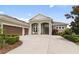 Charming home featuring a well-manicured lawn, a three car garage, and inviting front porch at 16697 Courtyard Loop, Land O Lakes, FL 34638