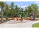Community playground featuring a slide, climbing wall, and seating around a cozy fire pit at 16697 Courtyard Loop, Land O Lakes, FL 34638