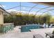 Screened-in pool area featuring bar, lounge chairs and lush tropical landscaping at 16697 Courtyard Loop, Land O Lakes, FL 34638