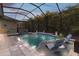 Private screened-in pool area with a jacuzzi, lounge chairs and backyard views at 16697 Courtyard Loop, Land O Lakes, FL 34638