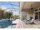 Enclosed pool area with comfortable lounge chairs and ceiling fan at 16697 Courtyard Loop, Land O Lakes, FL 34638