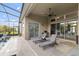 Screened-in pool features lounge chairs, ceiling fan, and outdoor kitchen area at 16697 Courtyard Loop, Land O Lakes, FL 34638