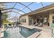 Inviting screened pool with sun shelf and backyard views at 16697 Courtyard Loop, Land O Lakes, FL 34638