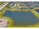 Scenic aerial view of home and surrounding neighborhood with a serene lake, showcasing the home's location at 1760 Fox Grape Loop, Lutz, FL 33558
