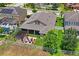 Aerial view of the home's backyard featuring a patio, fire pit, pergola, white picket fence, and green lawn at 1760 Fox Grape Loop, Lutz, FL 33558
