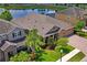 Gorgeous aerial view of home with water views and lush greenery, with driveway and landscaping at 1760 Fox Grape Loop, Lutz, FL 33558